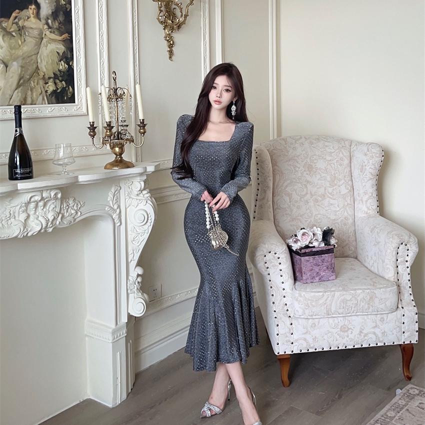 فستان نسائي أنيق بتصميم «هوت ليكشري» فرنسي ـ أمريكي، بياقة مربّعة، أكمام طويلة، خامة لامعة، وقصّة ذيل سمكة تضفي أنوثة راقية